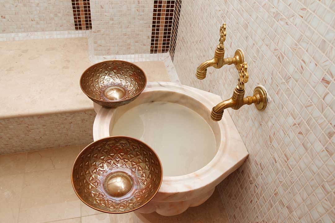 Beautiful turkish bath basin with coloured tiles and fancy taps