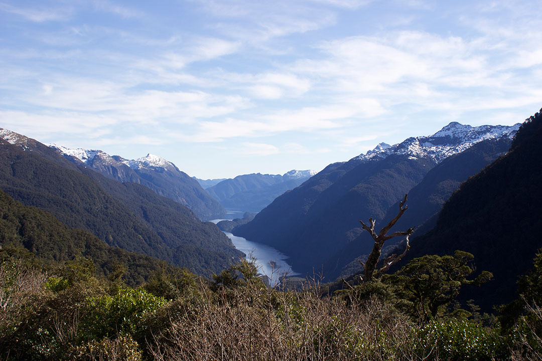 View from Wilmont Pass down to the lake between mighty snow-capped mountains in New Zealand