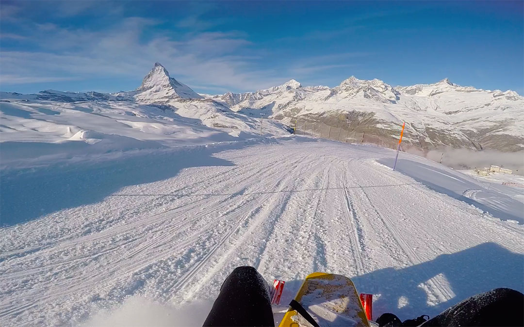 Beautiful snow covered Matterhorn in the distance against a blue winter sky while snow sledding