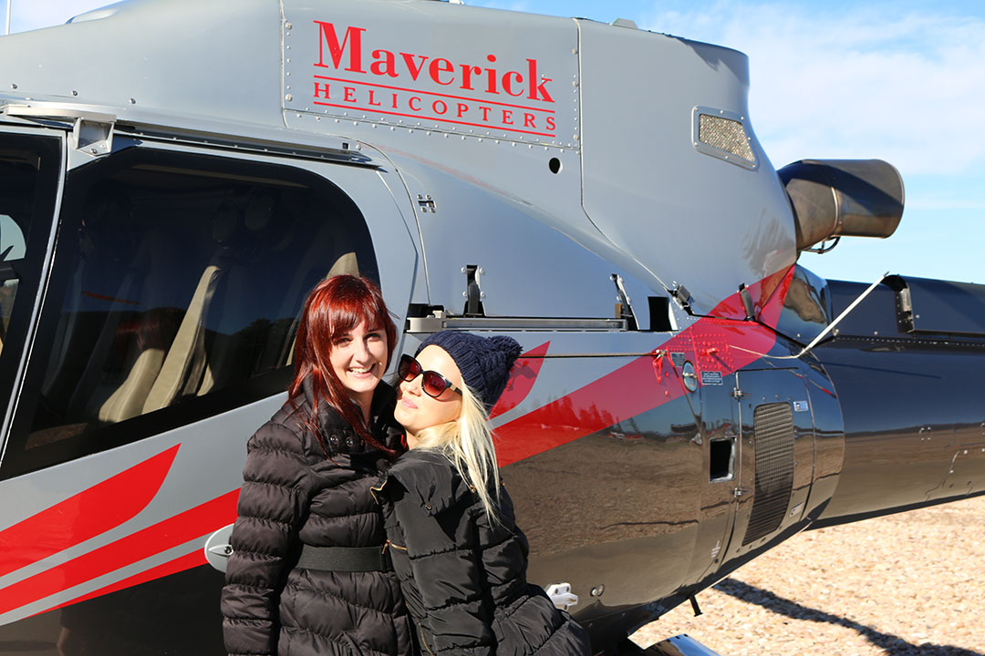 Keidi and I smiling and laughing while standing in front of the Maverick Helicopter at the Grand Canyon