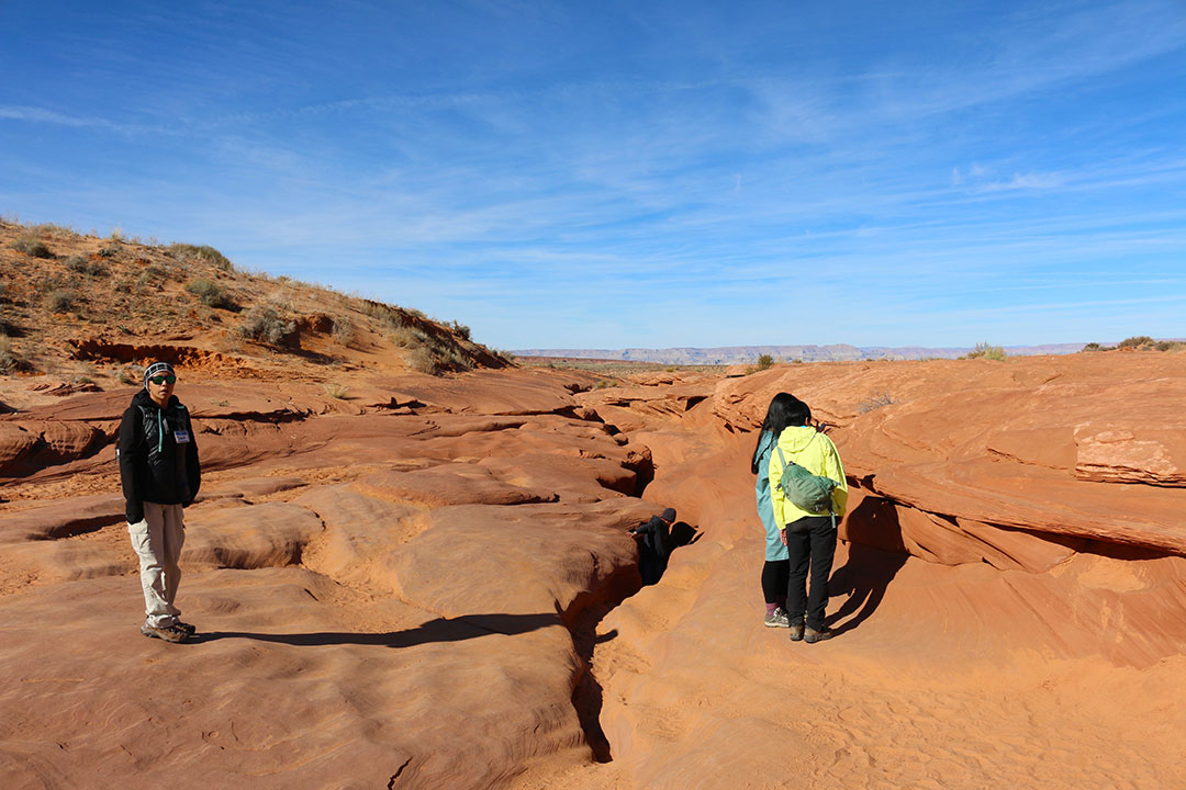 A person climbing out of the narrow canyon mouth