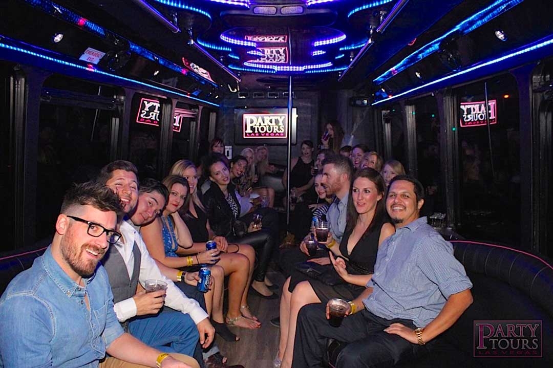 Group of friends drinking on the Party Tours bus lit up with neon lights