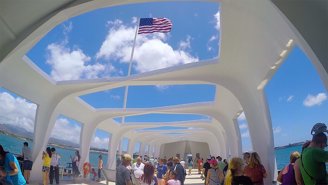 The American flag flies high in the memorial building above the sunken USS Arizona