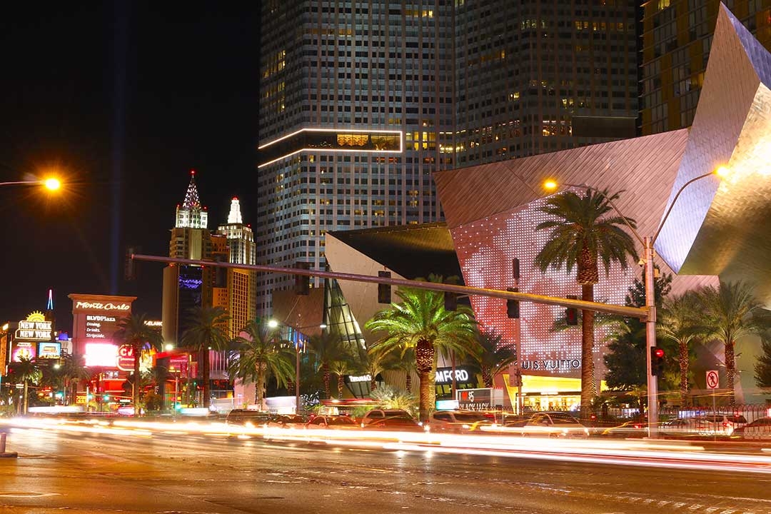 Bright lights of Las Vegas at night as the lights of cars fly by on the road