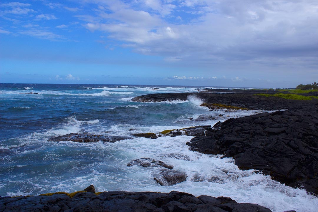 Punaluu Black Sand Beach in Hawaii on a summers day with waves crashing