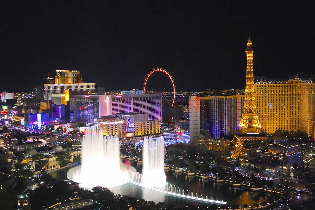 Las Vegas at night lit up with coloured buildings and giant water features