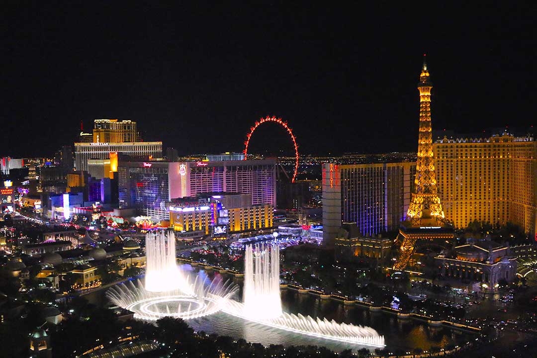 Las Vegas at night lit up with coloured buildings and giant water features