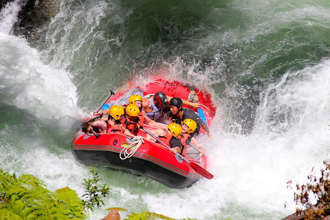 Mum and I with our group of white water rafters after we made it to the bottom of the 7 metre waterfall drop, everyone is happily screaming or smiling while holding on tight