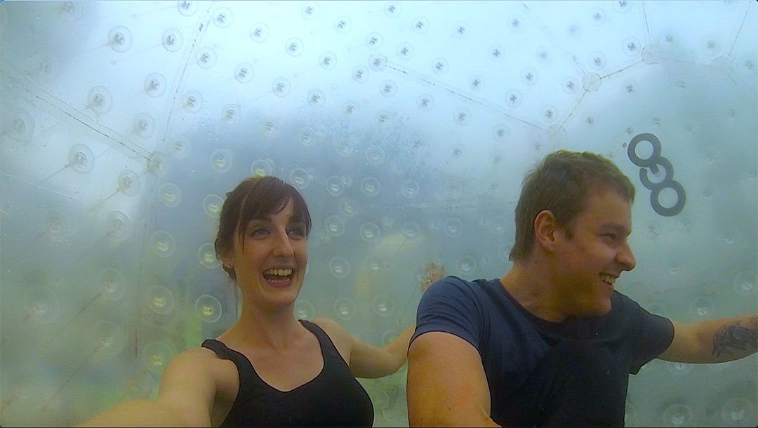 Casey and I inside the OGO Zorbing ball looking excited as it starts to roll down the zigzag path on the hill