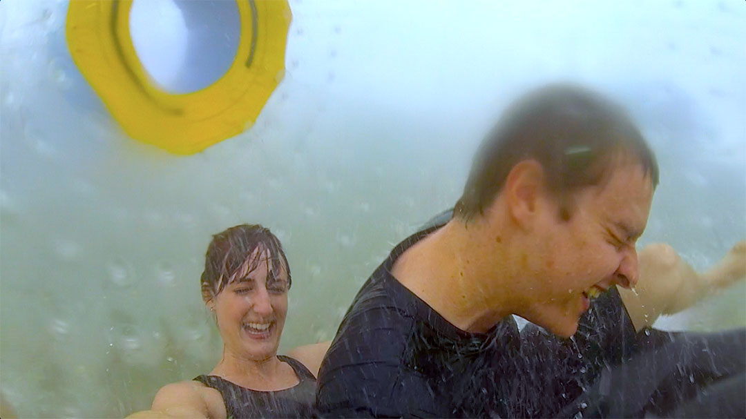 Casey and I drenched in water while Casey falls on top of me as we get thrown about inside the OGO Zorbing ball on the zigzag path