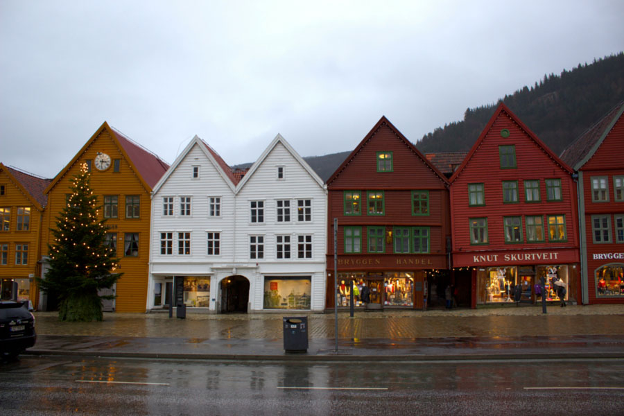 Colourful UNESCO buildings lined up side by side touching each other in Bergen, Norway during a rainy winter day