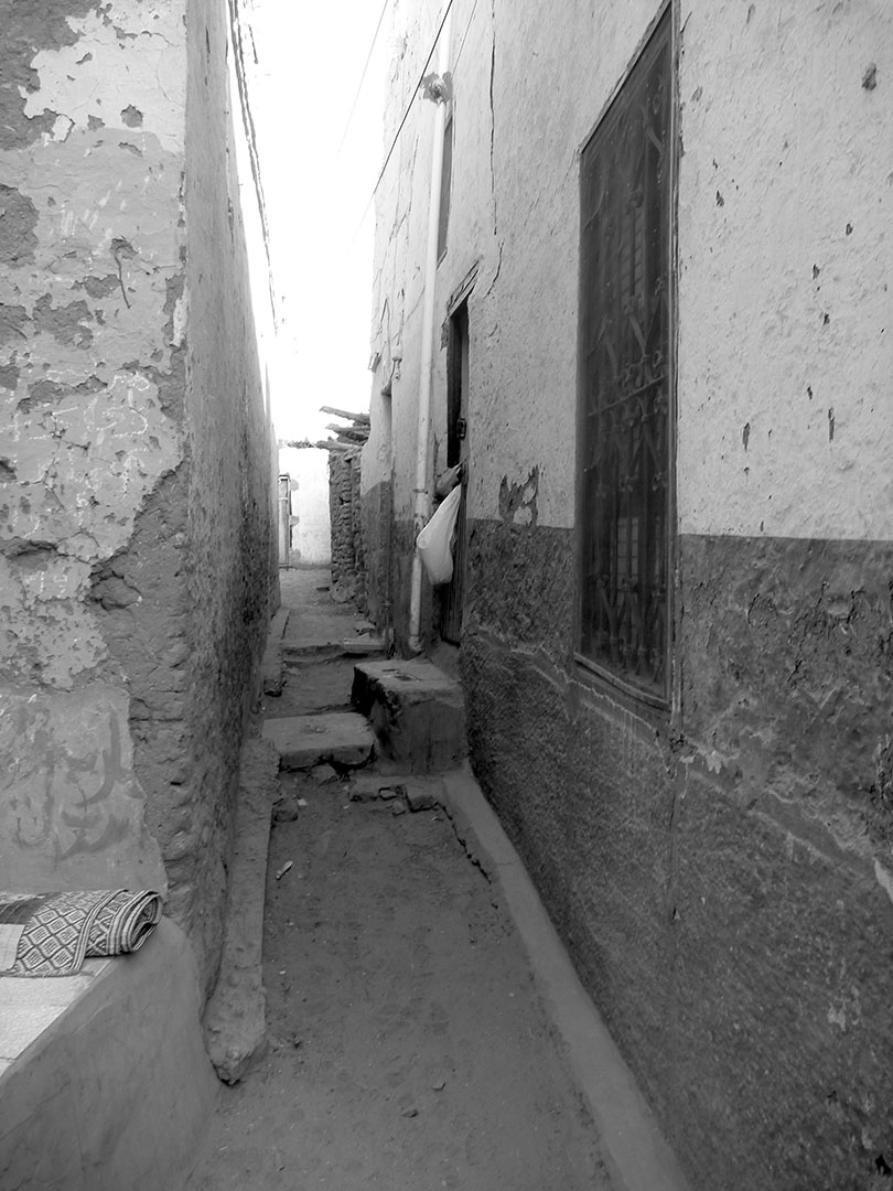 Quiet black and white walkways in a Nubian Village between old mud brick buildings