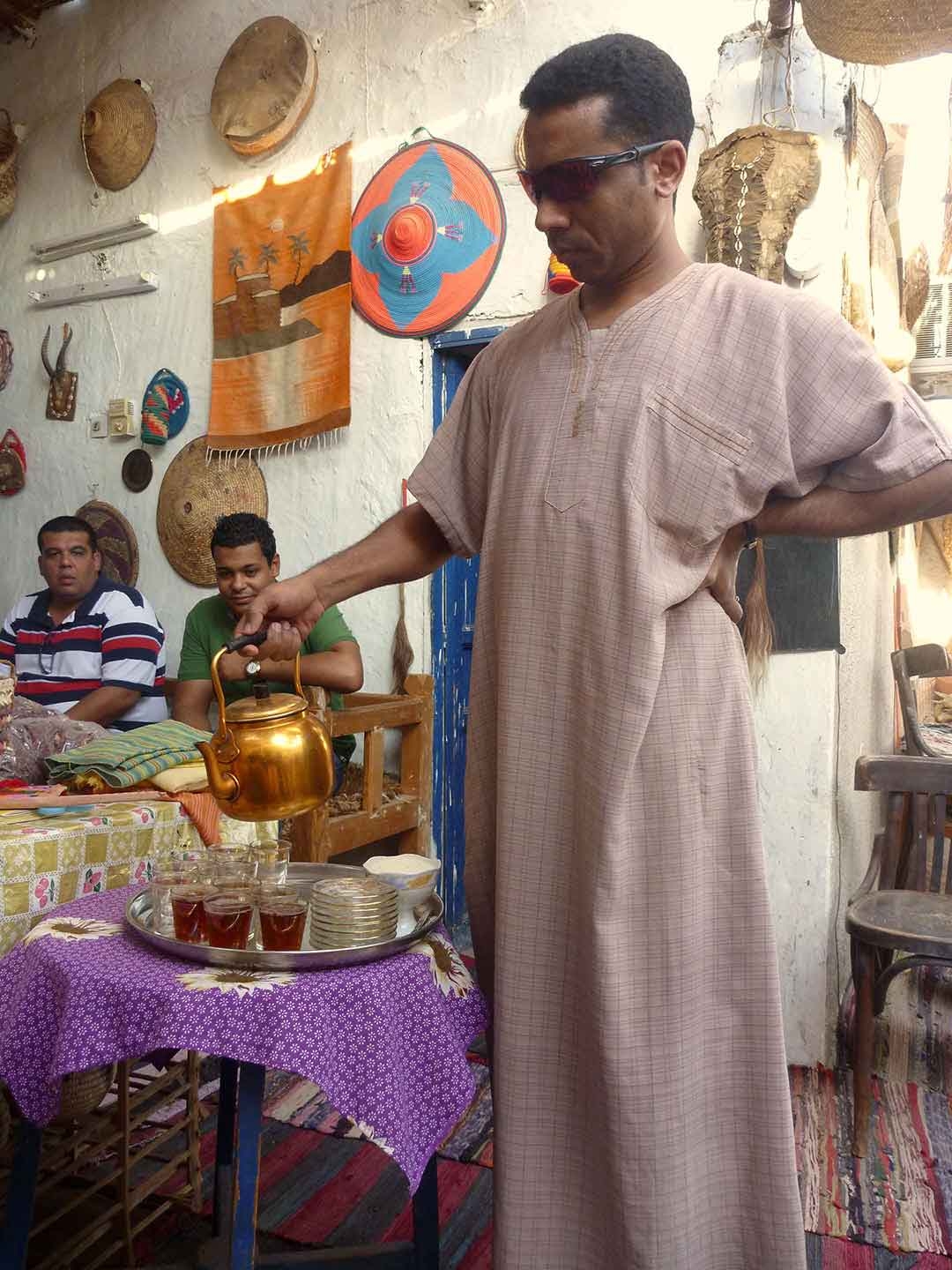 Nubian Village man pouring local tea especially made for us inside his mud brick home