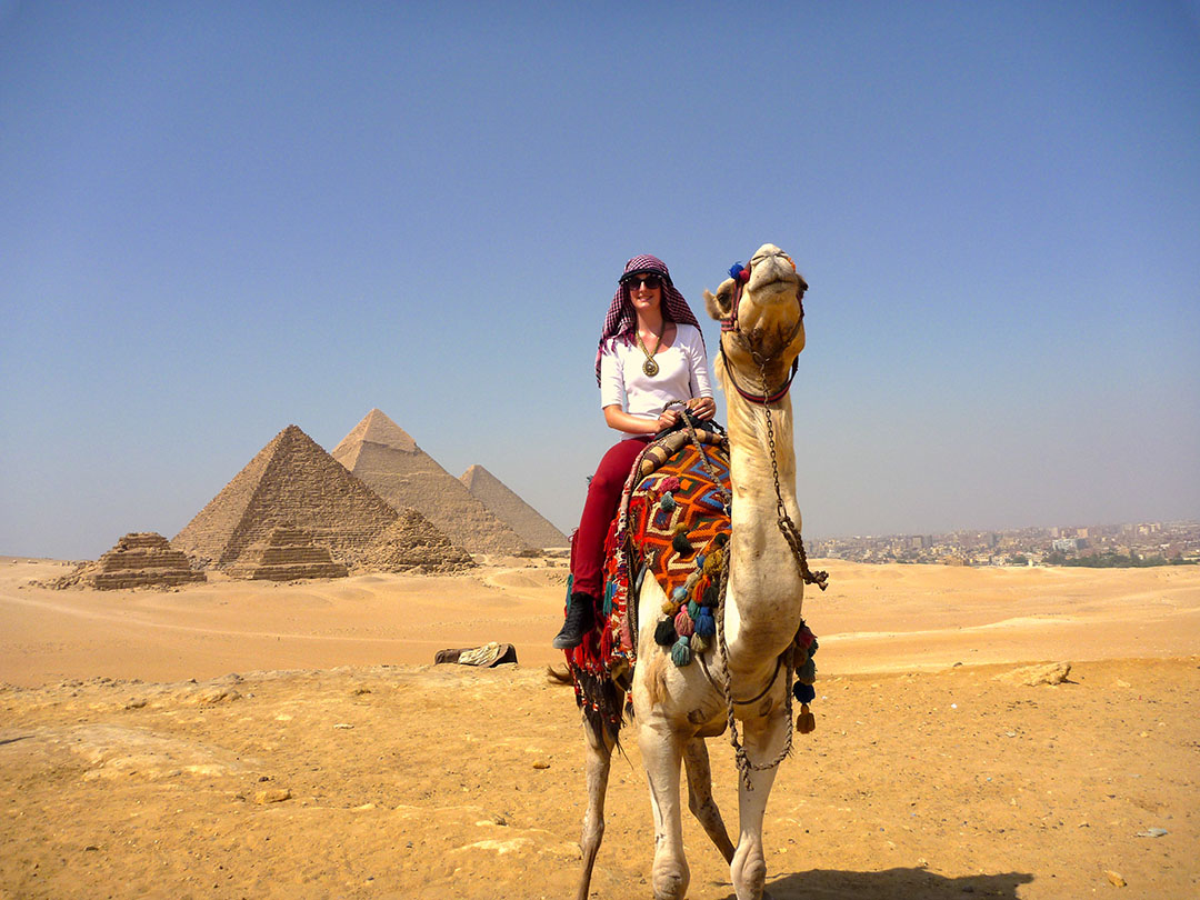 Me sitting on Charlie the camel in front of the Great Pyramids of Giza in Egypt