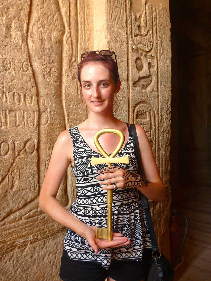 Me standing at the entrance to King Tut's tomb in the Valley of the Kings holding the golden key, in Egypt
