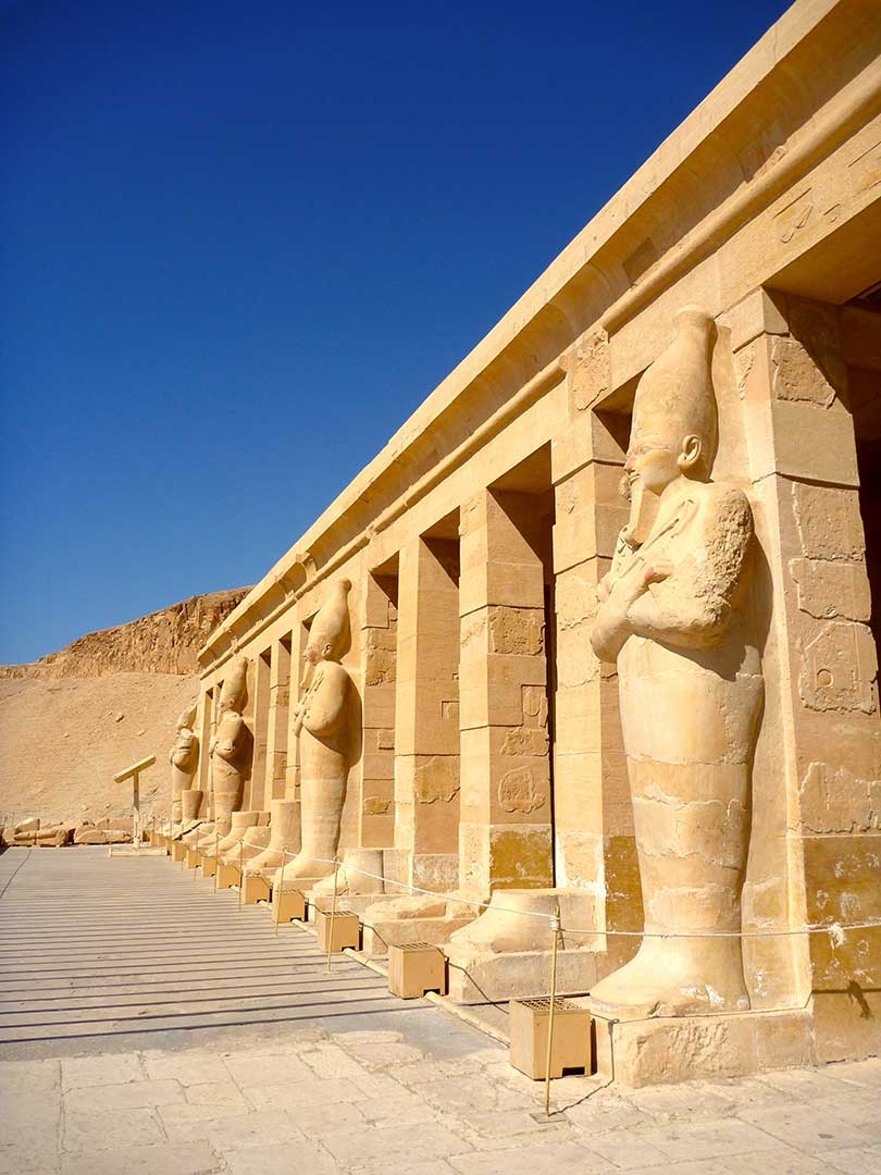 Side view of the front of Hatshepsut's Temple in Egypt with a perfectly blue summer sky