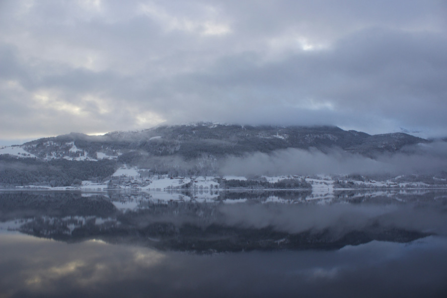 Mountain reflections on the lake in Voss, Norway on a cloudy winter day while on the Norway in a Nutshell self-guided tour