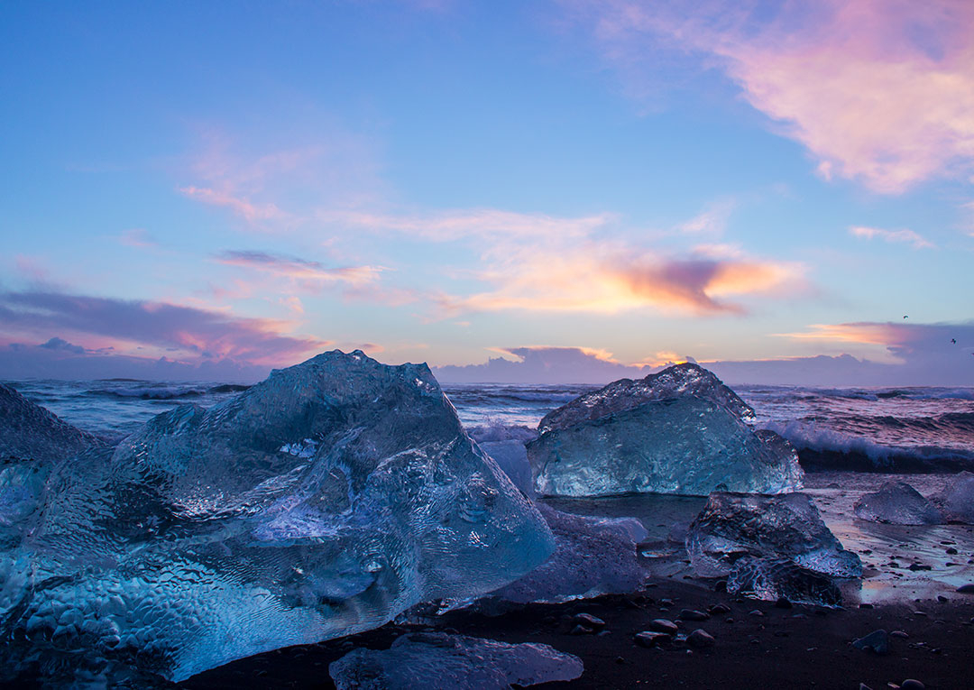 Diamond Beach at Jokulsarlon Glacier Lagoon at sunrise with icebergs on the black sand beach and pink skies